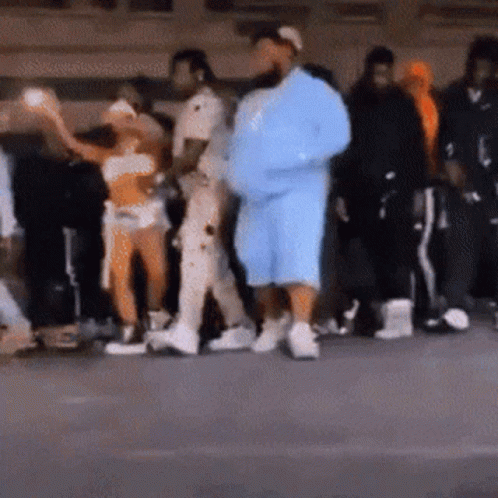 A Group Of People Are Standing In A Line . GIF