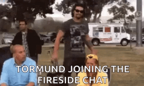 A Group Of People Are Standing In A Park And Talking To Each Other . GIF