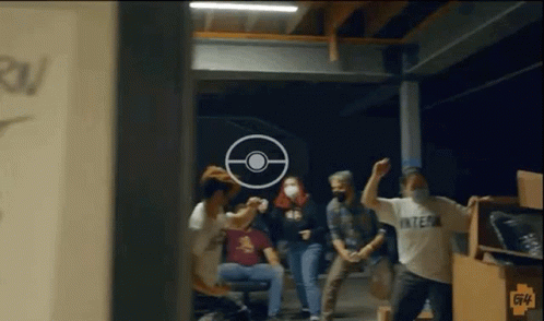 A Group Of People Are Standing In A Room With A Target In The Background . GIF