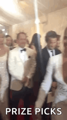 A Group Of People Are Standing In A Room With The Words `` Prize Picks '' Written On It . GIF