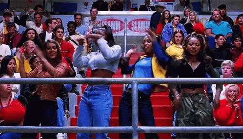 A Group Of People Are Standing In A Stadium Watching A Basketball Game And Dancing . GIF