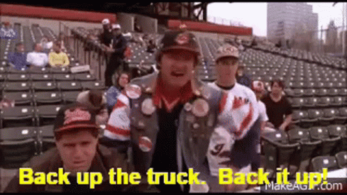 A Group Of People Are Standing In A Stadium With The Words `` Back Up The Truck , Back It Up '' Written On The Screen . GIF