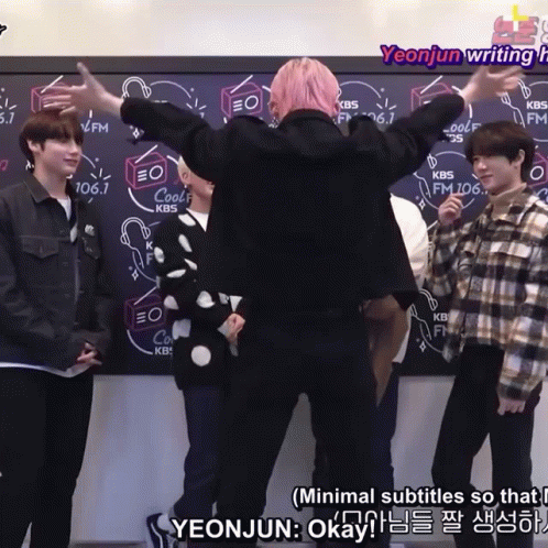 A Group Of People Are Standing In Front Of A Blackboard With Kbs Written On It GIF