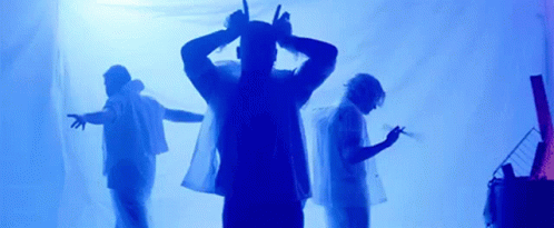 A Group Of People Are Standing In Front Of A Blue Background . GIF