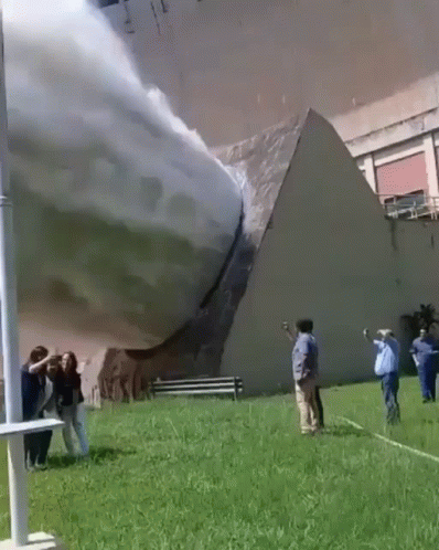 A Group Of People Are Standing In Front Of A Building That Has A Pyramid On It GIF