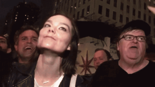 A Group Of People Are Standing In Front Of A Building That Says ' A & R ' On It GIF