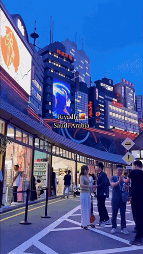 A Group Of People Are Standing In Front Of A Building That Says Riyadh On It GIF