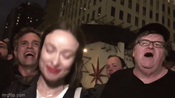 A Group Of People Are Standing In Front Of A Building With A Star On It . GIF