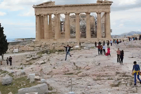 A Group Of People Are Standing In Front Of A Building With The Word Athens On It GIF
