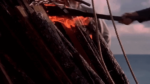A Group Of People Are Standing In Front Of A Burning Statue Of A Man GIF