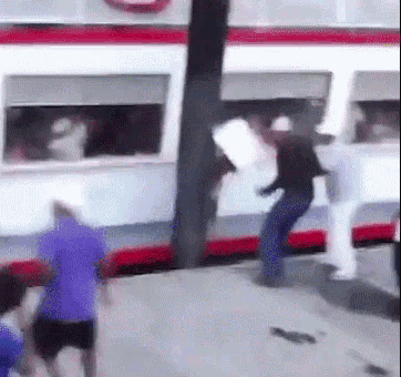 A Group Of People Are Standing In Front Of A Bus . GIF