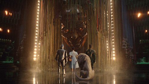 A Group Of People Are Standing In Front Of A Large Sculpture GIF