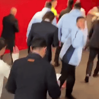 A Group Of People Are Standing In Front Of A Red Background GIF