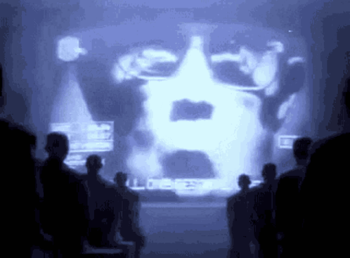 People Standing In Front Of Man's Face Screen GIF