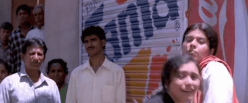 A Group Of People Are Standing In Front Of A Sign That Says Fanta GIF
