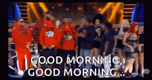 A Group Of People Are Standing In Front Of A Stage And A Sign That Says `` Good Morning , Good Morning '' . GIF