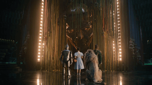 A Group Of People Are Standing In Front Of A Statue GIF