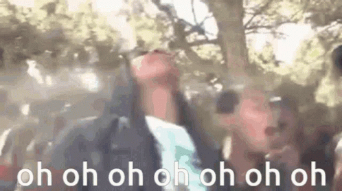 A Group Of People Are Standing In Front Of A Tree With Their Hands In The Air And The Words `` Oh Oh Oh Oh Oh Oh '' . GIF