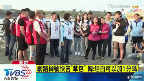 A Group Of People Are Standing In Front Of A Tvbs News Screen GIF