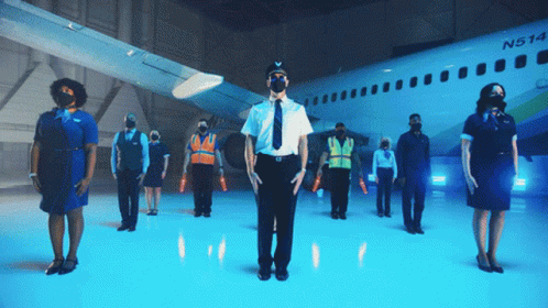 A Group Of People Are Standing In Front Of An Airplane With The Letters N And A On It GIF