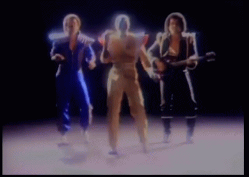 a group of people are standing next to each other and one of them is holding a guitar .