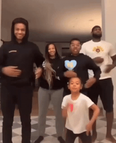 a group of people are standing next to each other dancing .