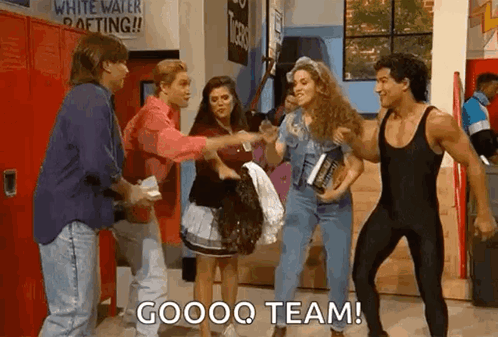 A Group Of People Are Standing Next To Each Other In A Hallway And One Of Them Is Holding A Book . GIF
