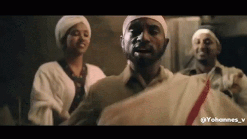 a group of people are standing next to each other in a room . one of the men is wearing a white turban .