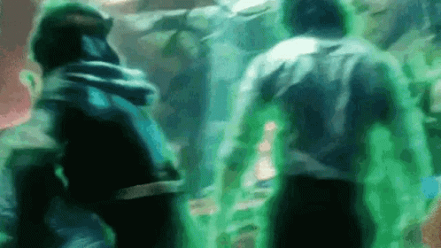 A Group Of People Are Standing Next To Each Other In A Room With Green Lights . GIF