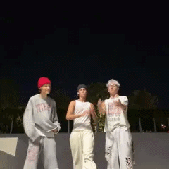 a group of people are standing next to each other in a skate park at night .