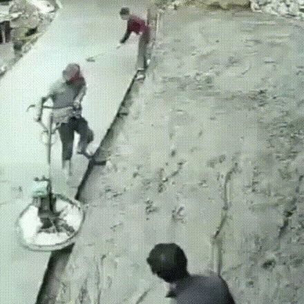 A Group Of People Are Standing On A Concrete Surface . GIF