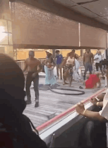 A Group Of People Are Standing On A Deck With A Hula Hoop GIF