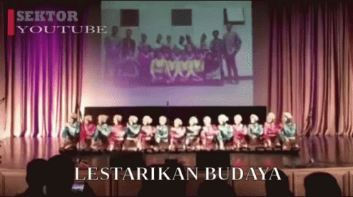 A Group Of People Are Standing On A Stage And The Words Lestarikan Budaya Are On The Screen GIF