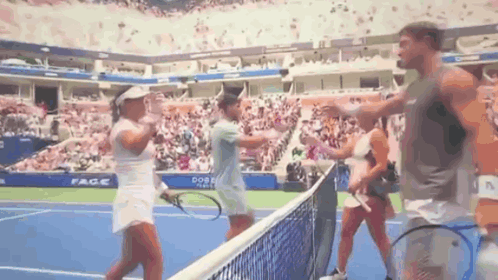 a group of people are standing on a tennis court with rackets .