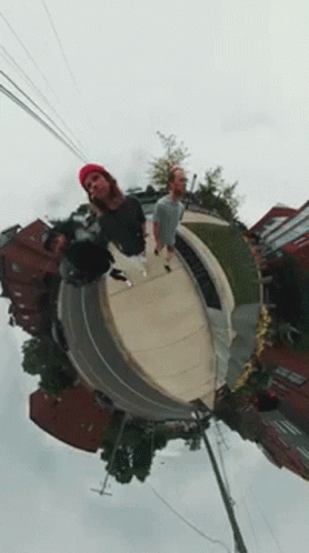 A Group Of People Are Standing On Top Of A Skateboard Ramp . GIF