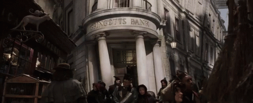 A Group Of People Are Standing Outside Of A Building That Says Gringotts Bank GIF