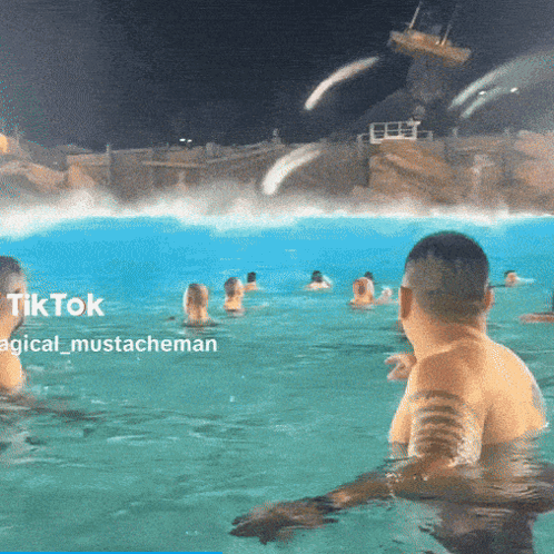 A Group Of People Are Swimming In A Pool At Night With A Caption That Says Tiktok Magical Mustacheman GIF