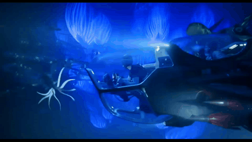 A Group Of People Are Swimming In An Aquarium With Sharks And Other Fish GIF