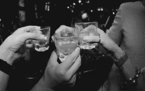 A Group Of People Are Toasting With Shot Glasses In Their Hands GIF