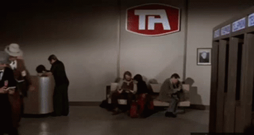 People Waiting In Room With TA Sign GIF
