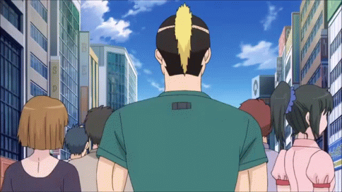 A Group Of People Are Walking Down A City Street With A Man Wearing A Green Shirt With The Letter L On It GIF