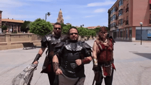 A Group Of People Are Walking Down A Street And One Of Them Is Wearing A Costume That Says ' Alianza ' GIF
