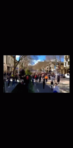 A Group Of People Are Walking Down A Street In A Blurry Photo GIF