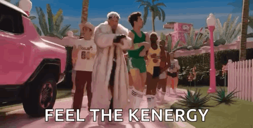 A Group Of People Are Walking Down A Street With The Words `` Feel The Keenergy '' Written On The Screen . GIF