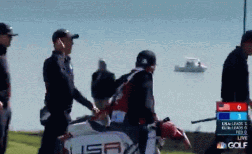 A Group Of People Are Walking On A Golf Course With A Scoreboard That Says Nbc Golf GIF