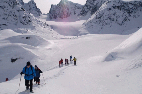 A Group Of People Are Walking Through The Snow GIF