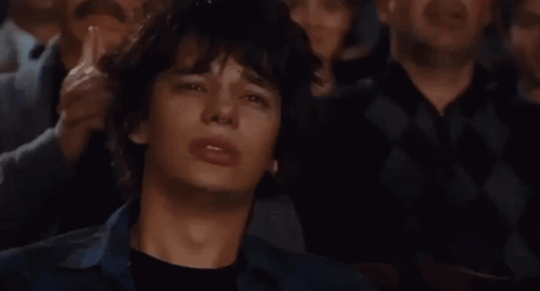 A Group Of People Are Watching A Movie And One Of Them Is Making A Funny Face GIF
