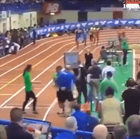 A Group Of People Are Watching A Track And Field Race GIF