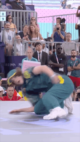 A Group Of People Are Watching A Wrestling Match With The Number 9 On The Screen GIF