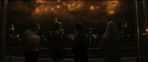 A Group Of People Are Watching Fireworks Over A City At Night GIF